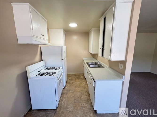 A small kitchen with white appliances and cabinets.