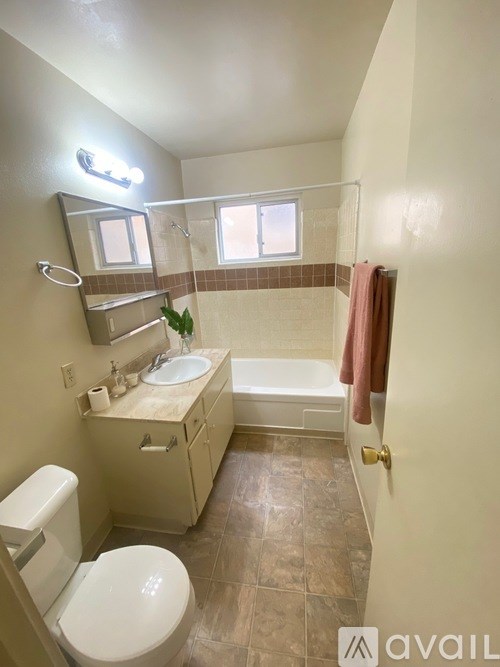A bathroom with a toilet, sink, and bathtub.