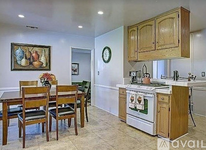 A kitchen with a table and chairs and a fridge.