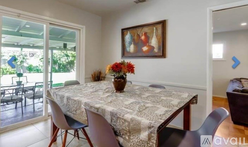 A dining room with a table and chairs.