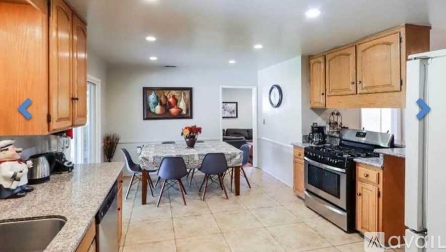 A kitchen with wooden cabinets and a dining table with chairs.
