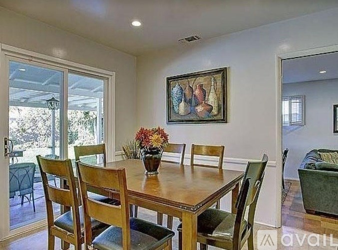 A dining room with a wooden table and chairs.