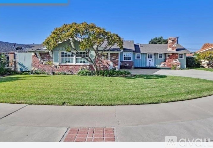 A house with a blue door and a tree in front.