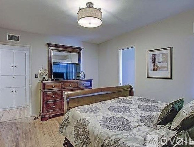 A bedroom with a bed, dresser, and mirror.