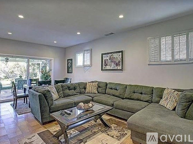 A living room with a grey sectional sofa and a coffee table.