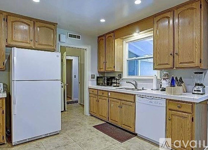A kitchen with wooden cabinets and a white refrigerator.