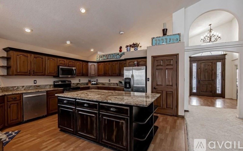 A kitchen with wooden cabinets and a granite countertop.