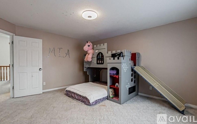 A child's bedroom with a bunk bed and a slide.