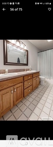 A bathroom with a large mirror and wooden cabinets.