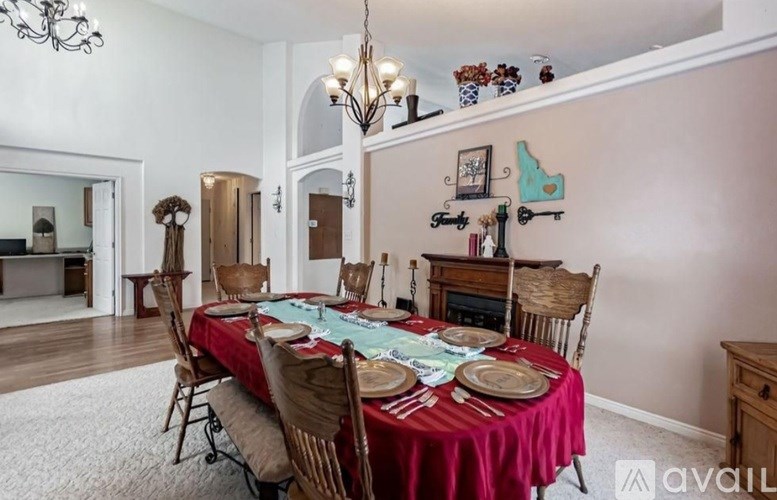 A dining room with a table set for a meal.