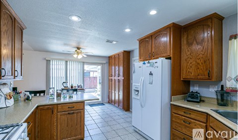 A kitchen with wooden cabinets and a white refrigerator.