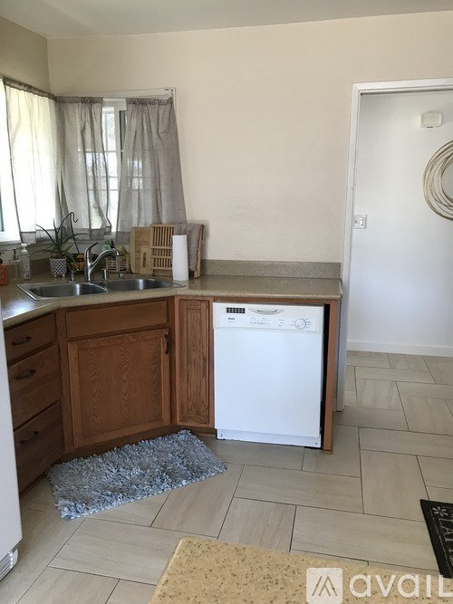 A kitchen with a washing machine in the middle of the room.