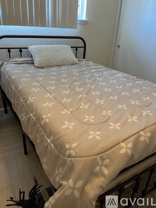 A bed with a white comforter and a pillow is in the image.