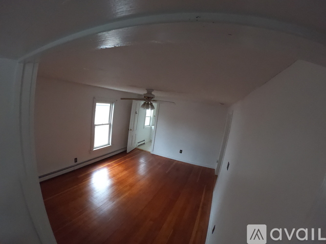 A room with wooden floors and a ceiling fan.