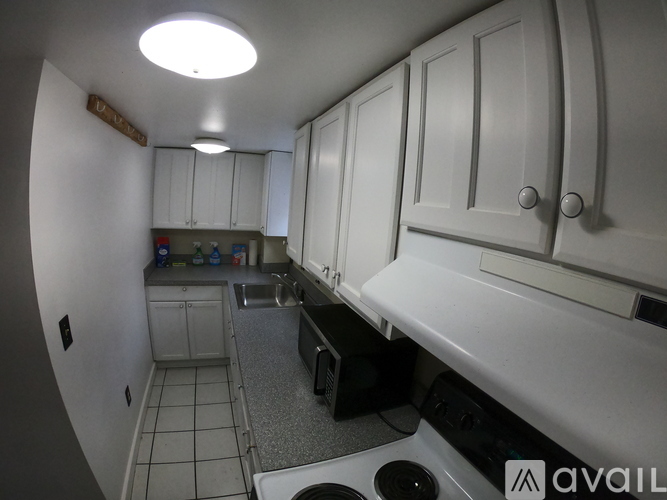 A kitchen with white cabinets and a black dishwasher.