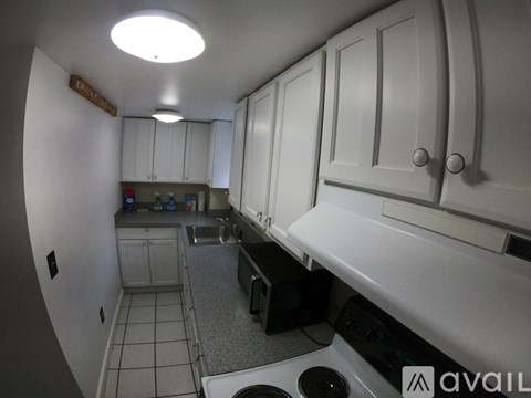 A kitchen with white cabinets and a black dishwasher.