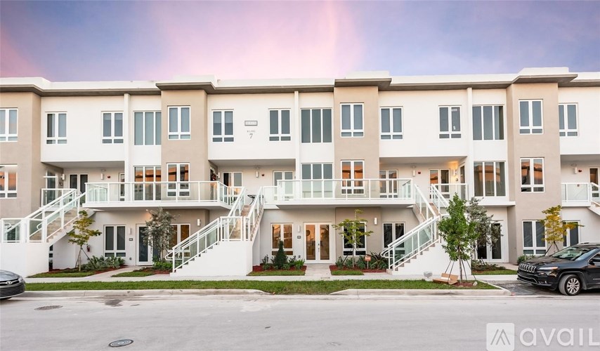 A row of townhouses with a car parked in front.
