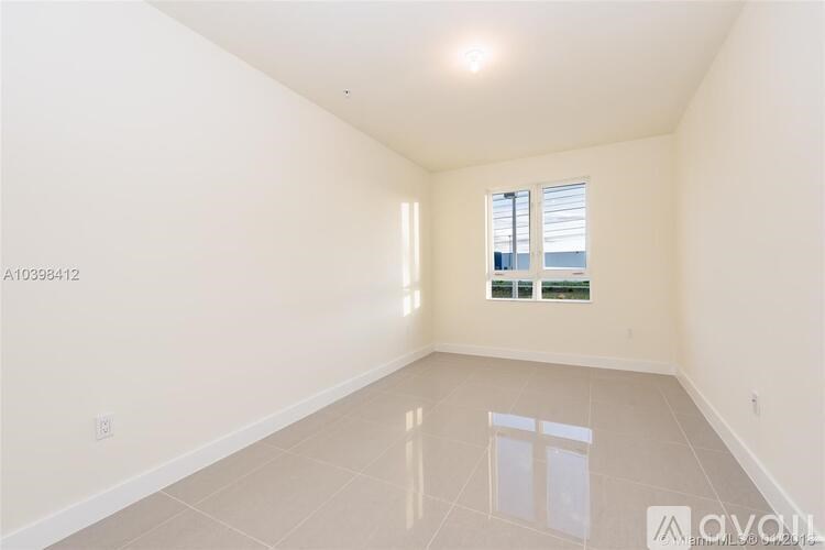 A large empty room with a window and a door.