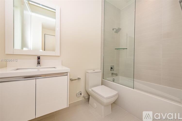 A white toilet sits next to a glass shower stall in a bathroom.