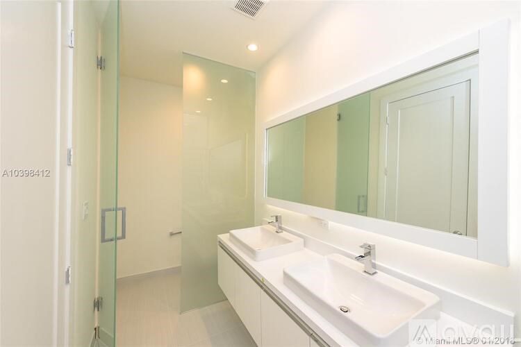 A bathroom with a sink, mirror, and glass shower door.
