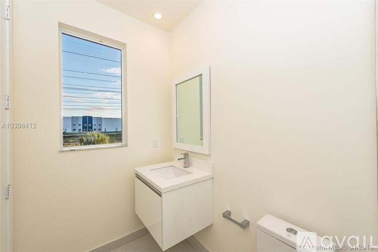 A small white bathroom with a window and a toilet.