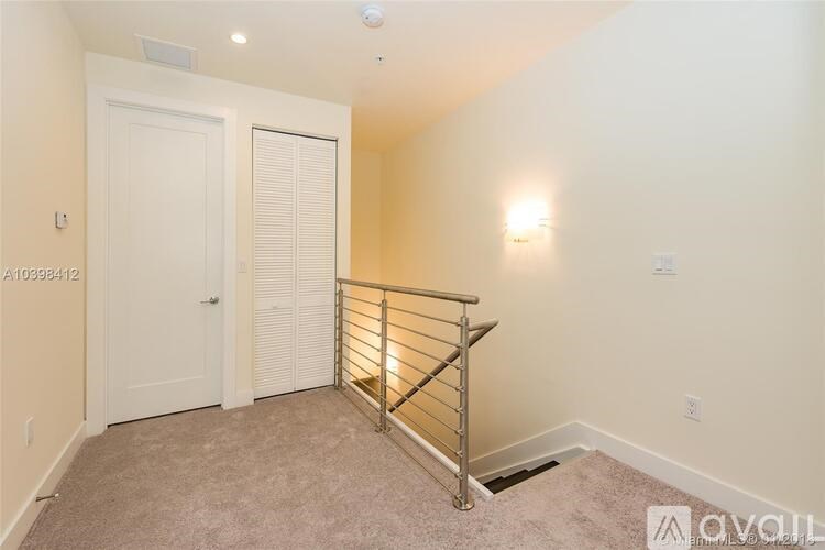 A room with a carpeted floor and a metal railing.