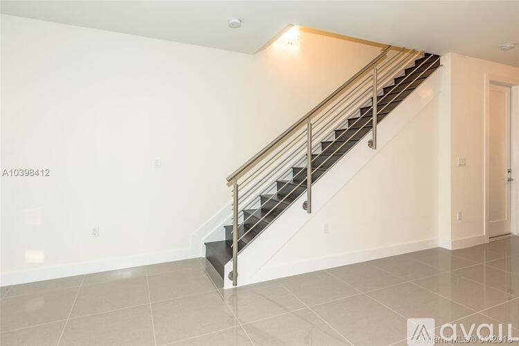 A staircase with a metal railing and a tiled floor.