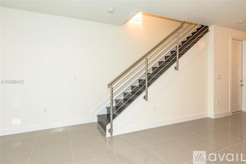 A staircase with a metal railing and a tiled floor.