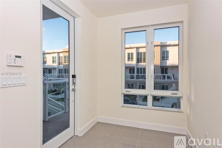 A room with a window showing a view of a building outside.