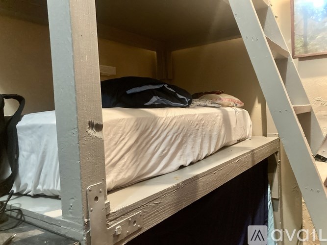 A bunk bed with a white sheet and a black blanket on top.