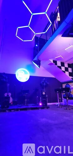 A neon sign in the shape of a hexagon is lit up in a room.