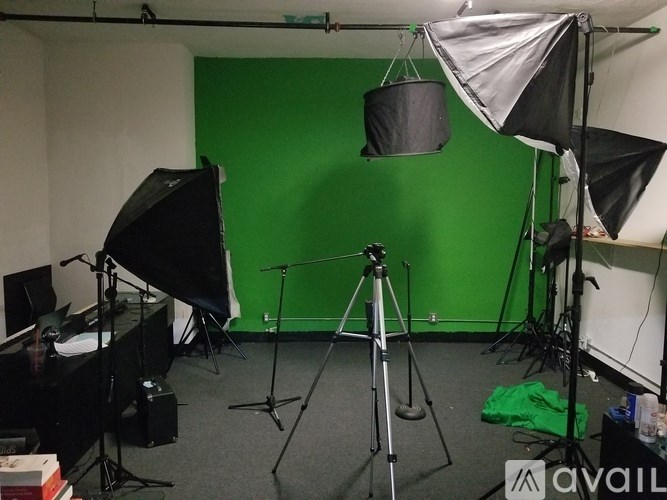 A photo studio with a green screen and lighting equipment.