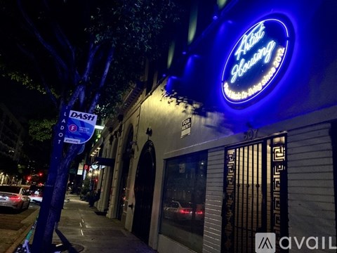 A blue lit up sign for "Ask Showing" is on a building.