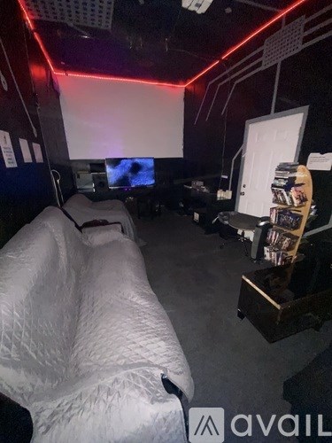 A movie theater with a screen and a row of seats.