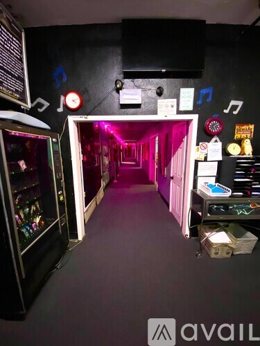A room with a neon pink light at the end of the hallway.