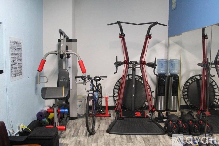 A gym with exercise equipment including a stationary bike and a rowing machine.