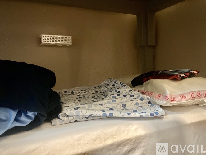 A bed with pillows and a blanket in a room.