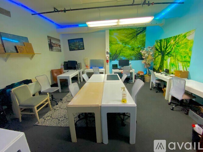 A room with a long table and chairs, a whiteboard, and a green tree mural on the wall.