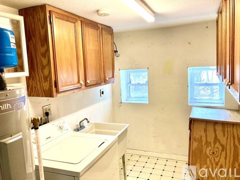 A kitchen with wooden cabinets and a white sink.