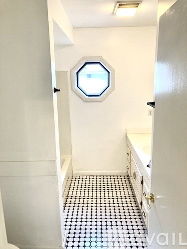 A bathroom with a black and white checkered floor.