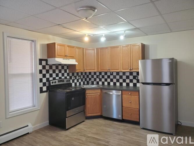A kitchen with black and white checkered tiles on the wall.