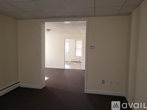 A room with a carpeted floor and a doorway leading to another room.