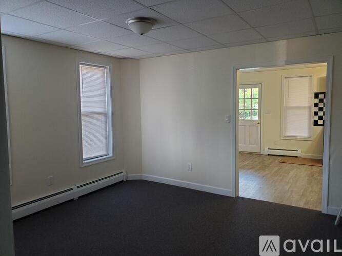 A room with a window and a door leading to another room.