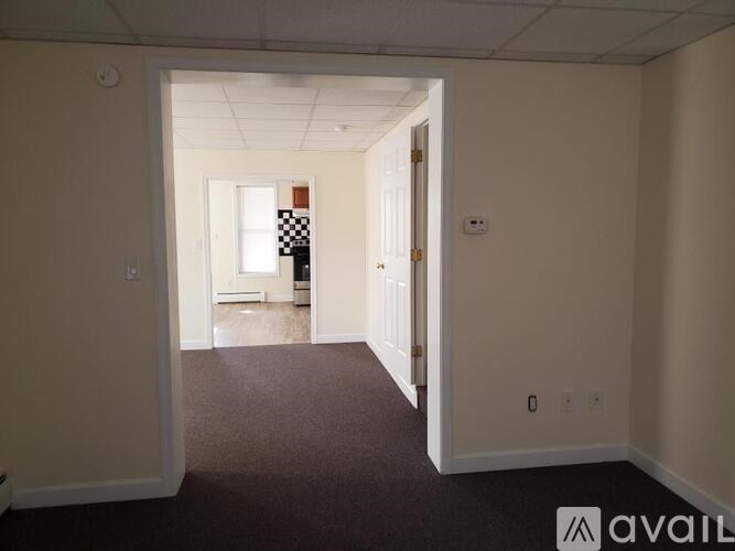 A room with a carpeted floor and two doors, one of which is open.