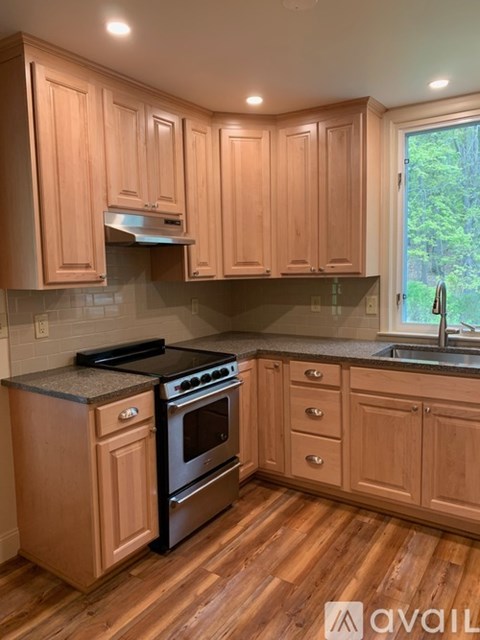 A kitchen with wooden cabinets and a black stove top oven.