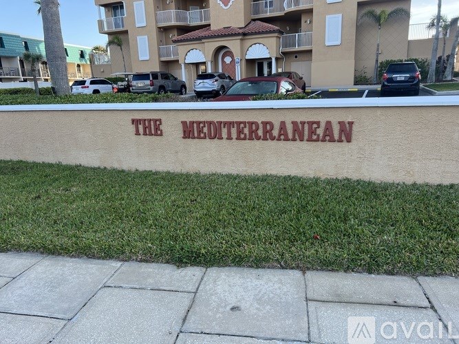 A building with a sign that says "The Mediterranean" in front of it.