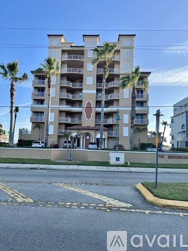 A tall apartment building with a red circle and white line on the front.