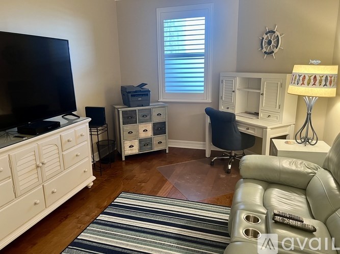 A living room with a white couch and a television.