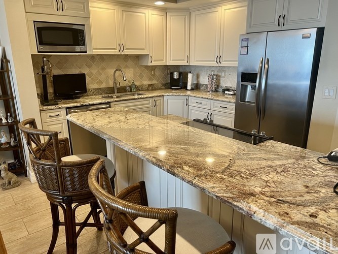 A kitchen with granite countertops and a refrigerator.