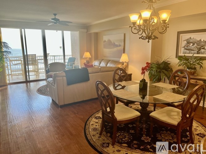 A living room with a couch, chairs, and a dining table.